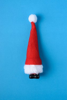 Mavi zemin üzerine minyatür Noel Baba. Yılbaşı yeni yıl en az kavramı.