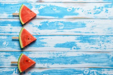 Karpuz dilimi dondurmayı mavi ahşap arka plan üzerinde.