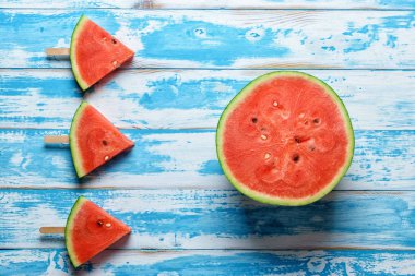 Karpuz dilimi dondurmayı mavi ahşap arka plan üzerinde.