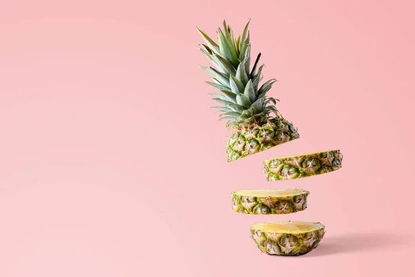 Sliced pineapple on pink bright background. Minimal fruit concept.