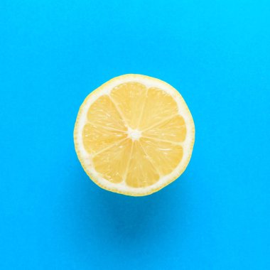 Parlak mavi zemin üzerine taze limon dilimi. Yaz en az kavramı.