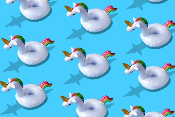 Inflatable unicorn pool toy pattern onl blue background. Minimal summer concept.