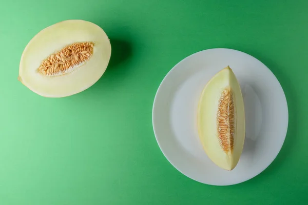 Melon sliced on bright green background. Minimal fruit concept.