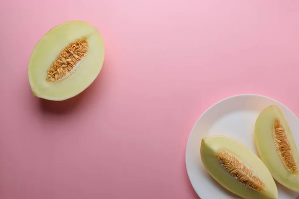 Melon sliced on pastel pink background. Minimal fruit concept.