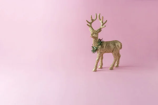 金色闪闪发光的驯鹿在粉红色的背景 最少的新年构成 — 图库照片
