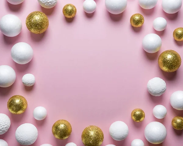 Golden and white glitter ball decoration on pink background with copy space. New Year minimal concept. Flat lay.