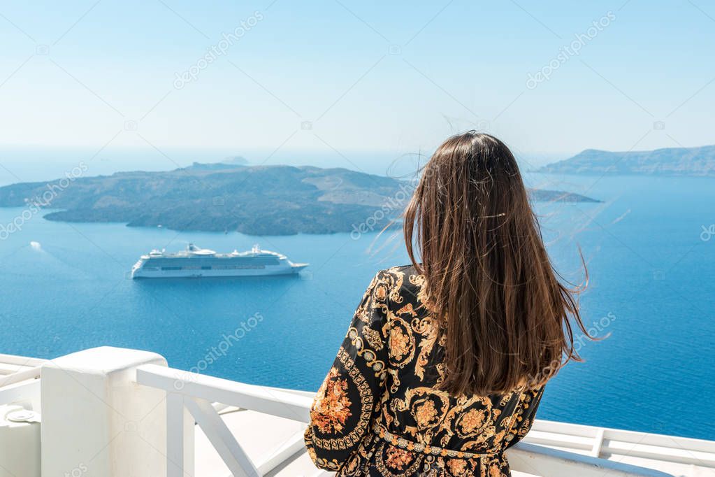 Beautiful woman enjoying view of Santorini island and Caldera in Aegean sea. Greece.
