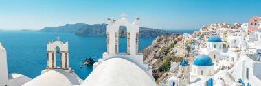 Geleneksel ve ünlü Oia beldesi panoramik manzaralı evler ve Caldera Santorini Adası üzerinde mavi kubbeler ile kiliseleri. Yunanistan.