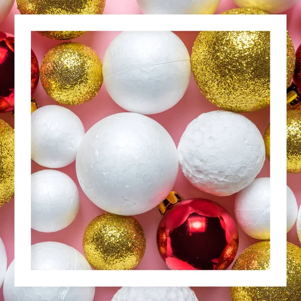 Gold and white glitter ball decoration with red Christmas bauble on pink background. New Year minimal concept. Close-up.