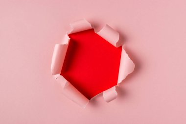 Canlı pembe yırtık kağıt patlama delik arka plan ile. En az soyut kavram.