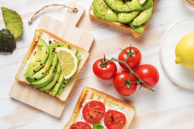 Tost ekmeği ile baharat beyaz ahşap zemin üzerinde üzerinde avokado dilimlenmiş. Gıda kavramı.