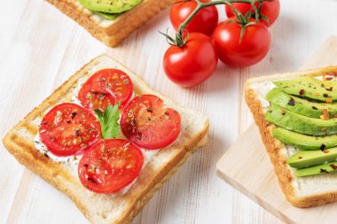 Tost ekmeği ile baharat beyaz ahşap zemin üzerinde üzerinde avokado dilimlenmiş. Gıda kavramı.