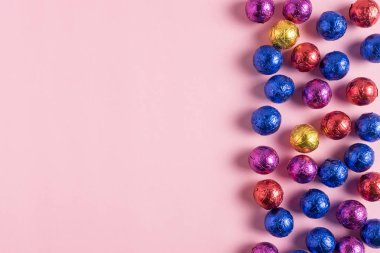 Pembe bir arka plan üzerinde renkli şeker yaratıcı düzeni. En az tatil kavramı.