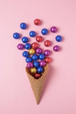 Dondurma külahı pembe bir arka plan üzerinde renkli candyes ile. En az tatil kavramı.