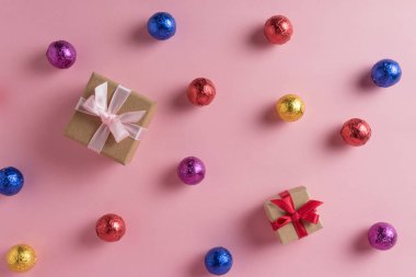 Pembe bir arka plan üzerinde renkli şeker ve Hediyelik kutu yaratıcı düzeni. En az tatil kavramı.