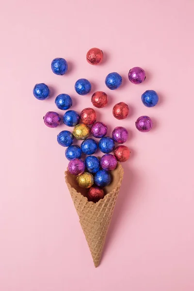 冰淇淋锥与彩色糖果粉红色的背景 最小的假期概念 — 图库照片