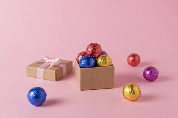 在粉红色的背景上的彩色糖果和礼品盒的创造性布局 最小的假期概念 — 图库照片