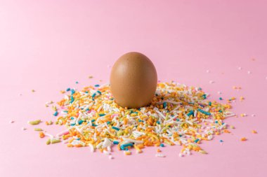 Pembe bir arka plan üzerinde renkli şeker ile yumurta. En az Paskalya kavramı.