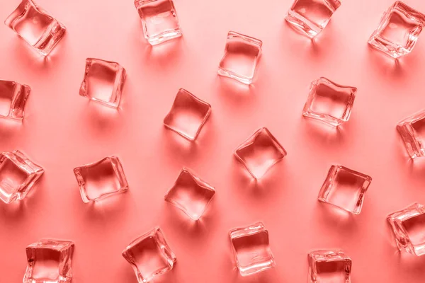 Cubos de gelo no fundo de cor de coral. Conceito mínimo de bebida de verão — Fotografia de Stock