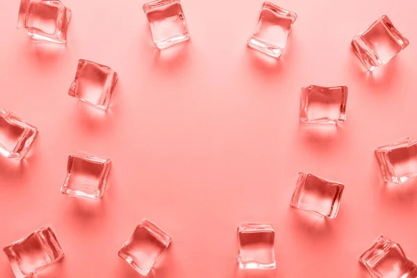 Cubes de glace sur fond de couleur corail. Concept de boisson estivale minimale — Photo
