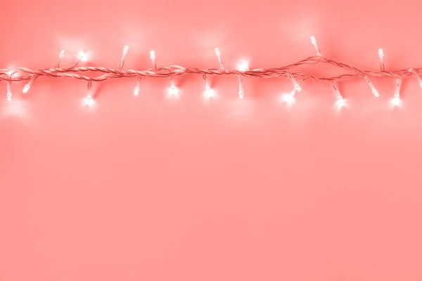 Layout criativo de luzes de Natal no fundo de cor de coral . — Fotografia de Stock