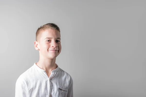 Mosolyogva Aranyos fiú világos háttéren fehér ing. — Stock Fotó
