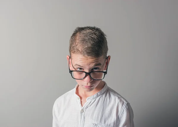 Tinédzser fiú szemüvegek és világos háttéren fehér ing. — Stock Fotó