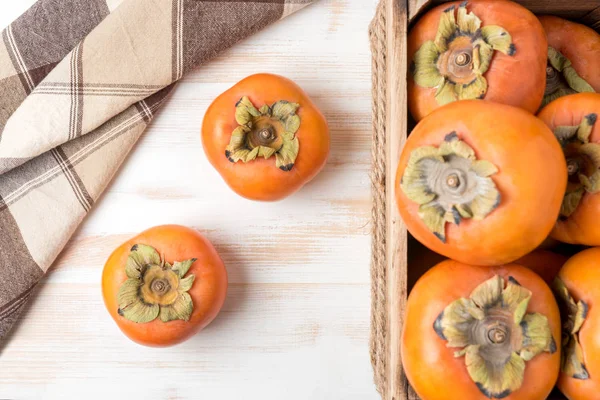 Delicious fresh persimmon fruits on wooden table. — Stock Photo, Image