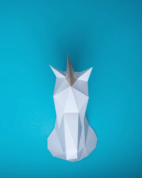 Witte 3d papercraft model van hoofd van de Eenhoorn op blauwe achtergrond. Minimal art concept. — Stockfoto