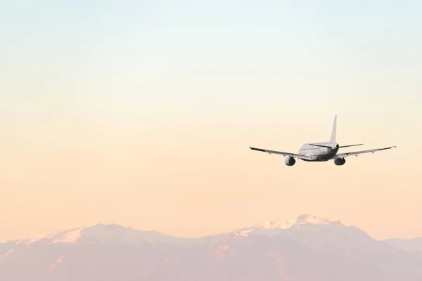 Vliegtuig vliegen over de zee en de bergen. Travel concept. — Stockfoto