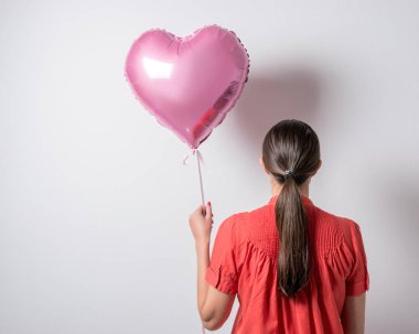 Güzel genç kadın kalbi olan parlak bir arka plan üzerinde balon şeklinde. Sevgililer günü kavramı.