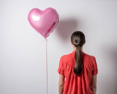 Güzel genç kadın kalbi olan parlak bir arka plan üzerinde balon şeklinde. Sevgililer günü kavramı.