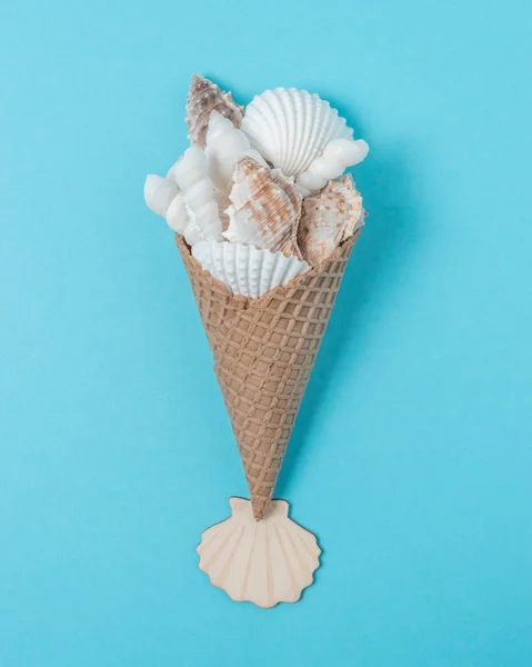 Composición creativa con conchas marinas y cono de helado sobre fondo azul pastel. Concepto mínimo de verano . — Foto de Stock
