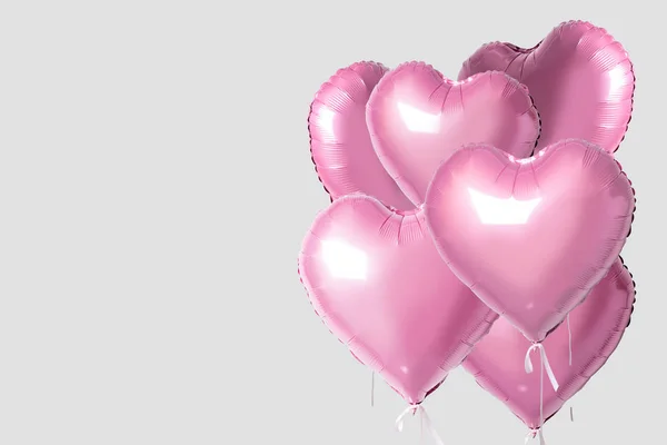 Manojo de globos de papel de aluminio en forma de corazón de color rosa aislados sobre un fondo brillante. Concepto de amor mínimo . —  Fotos de Stock