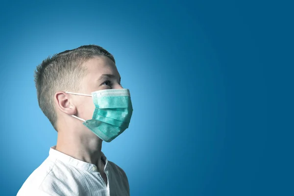 Ragazzino, un bambino con una maschera medica su uno sfondo brillante. L'idea di un'epidemia, influenza, protezione dalle malattie, vaccinazione . — Foto Stock