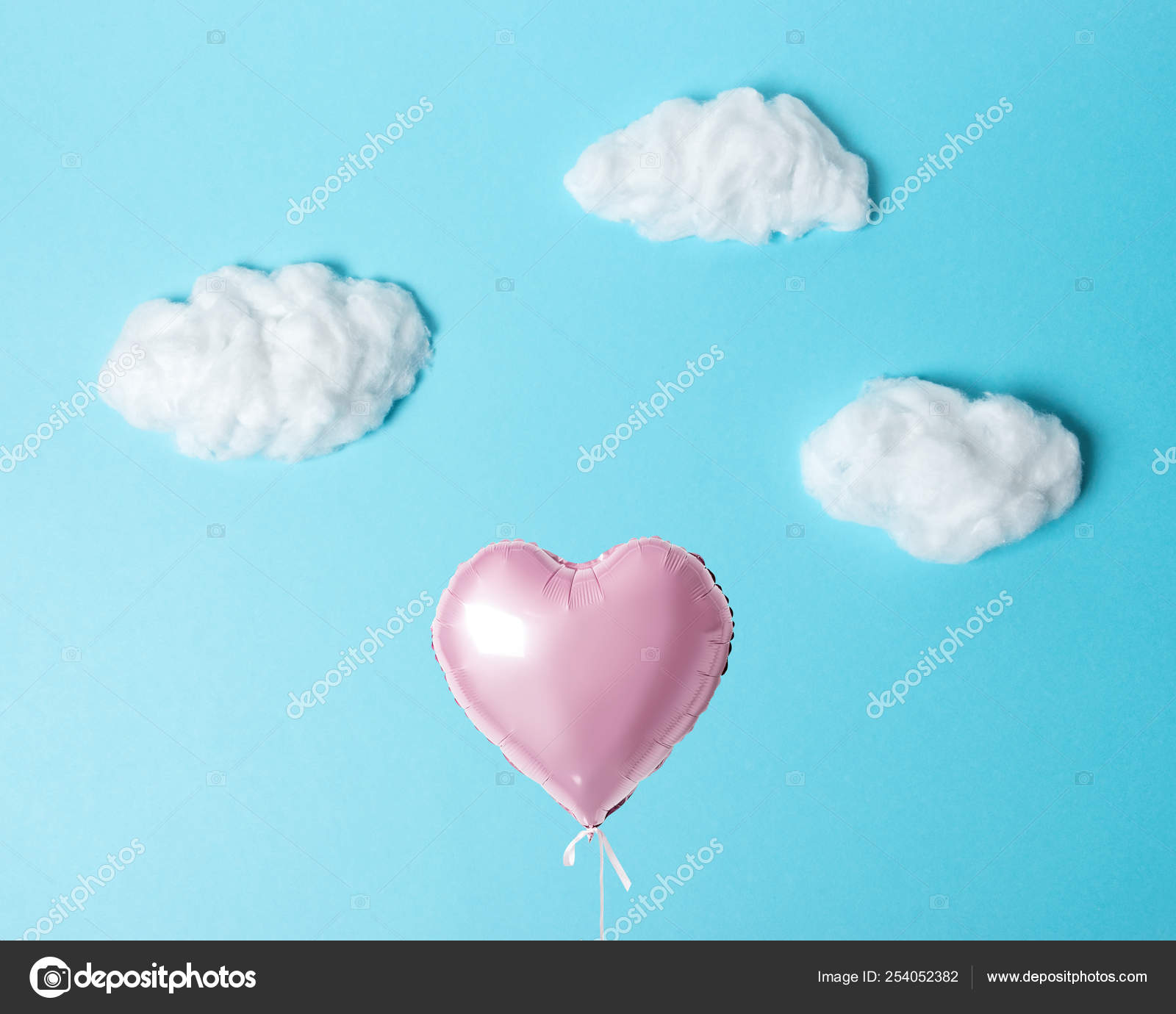 White Cotton Clouds with Pink Heart Balloon on Pastel Blue