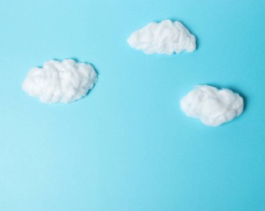 Pastel mavi zemin üzerine beyaz pamuk bulutlar. En az kavramı.