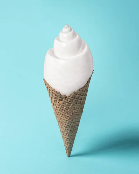Kreatív összetétele, a kagyló és a fagylalt kúp, pasztell kék háttér. Nyári minimális koncepció. — Stock Fotó