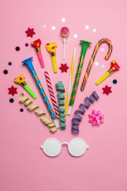 Renkli kutlama arka plan beyaz güneş gözlüğü, çeşitli parti konfeti, flamalar ve dekorasyon ile. En az parti kavramı. Düz yatıyordu.