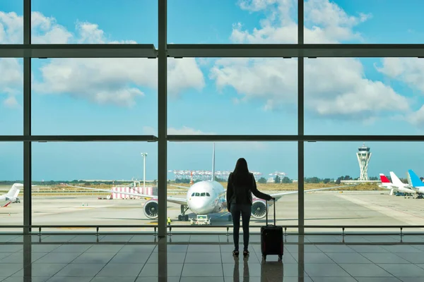 Молодая женщина с чемоданом в зале вылета в аэропорту. Концепция путешествия . — стоковое фото