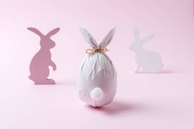 Paskalya yumurtası tavşanlar dekorasyon ile bir tavşan şeklinde bir kağıda sarılmış. Minimal Paskalya konsepti.