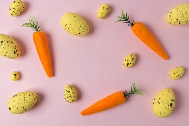 Pembe arka planda havuç ve renkli yumurta yaratıcı Paskalya deseni. Minimal Paskalya kompozisyon. Düz yatma.