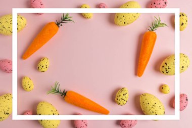 Pembe arka planda havuç ve renkli yumurta yaratıcı Paskalya deseni. Minimal Paskalya kompozisyon. Düz yatma.