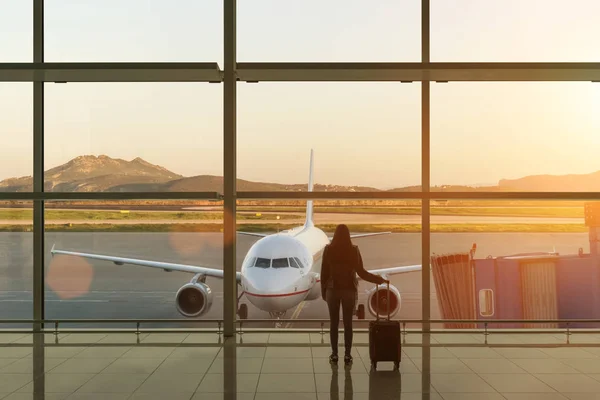 Mujer joven con maleta en la sala de embarque del aeropuerto. Concepto de viaje . —  Fotos de Stock