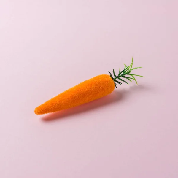 Морквяна прикраса на пастельно-рожевому тлі. Мінімальна весняна композиція . — стокове фото