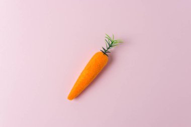 Pastel pembe arka planda havuç dekorasyon. Minimal bahar bileşimi.