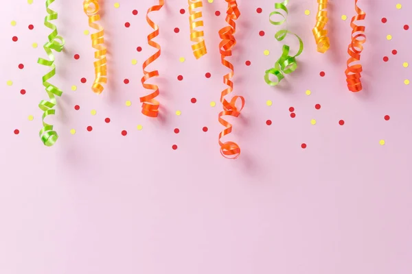 Coloridas serpentinas de fiesta sobre fondo rosa. Concepto de celebración mínima. Puesta plana . —  Fotos de Stock