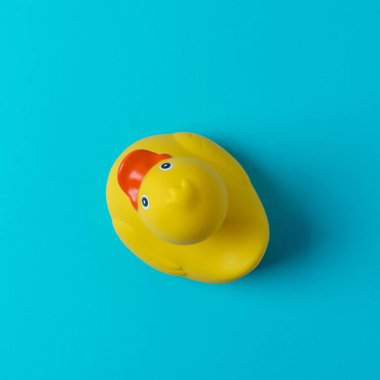 Mavi arka planda sarı plastik ördek. Yaz asgari kavramı.