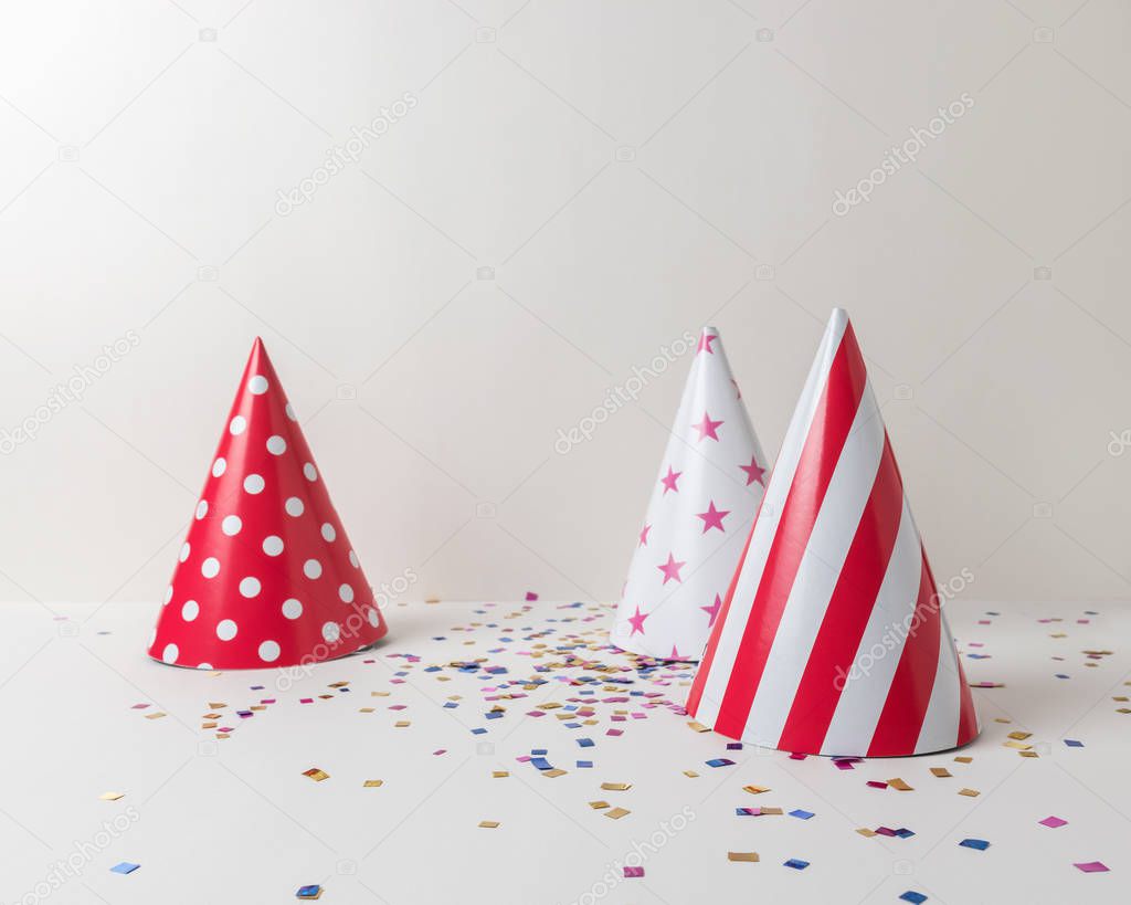 Colored confetti and party hat on white background. Minimal party concept.