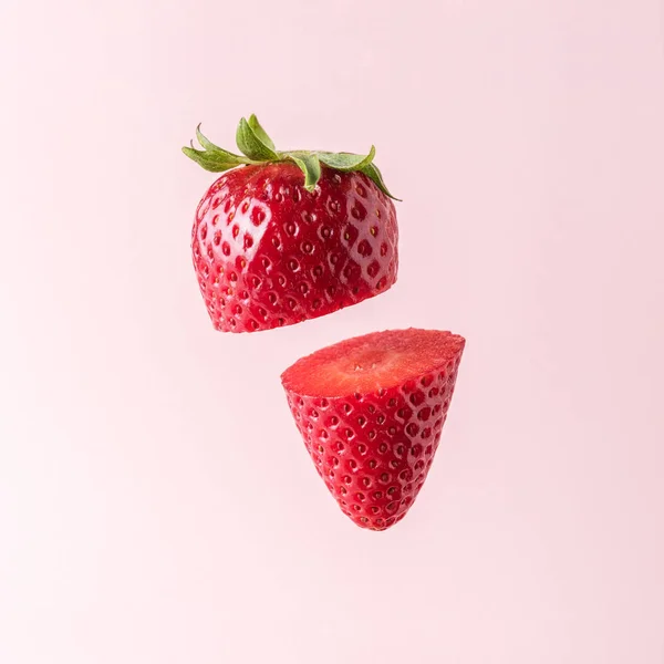 Erdbeere in Scheiben geschnitten auf pastellrosa Hintergrund. Minimales Fruchtkonzept. — Stockfoto